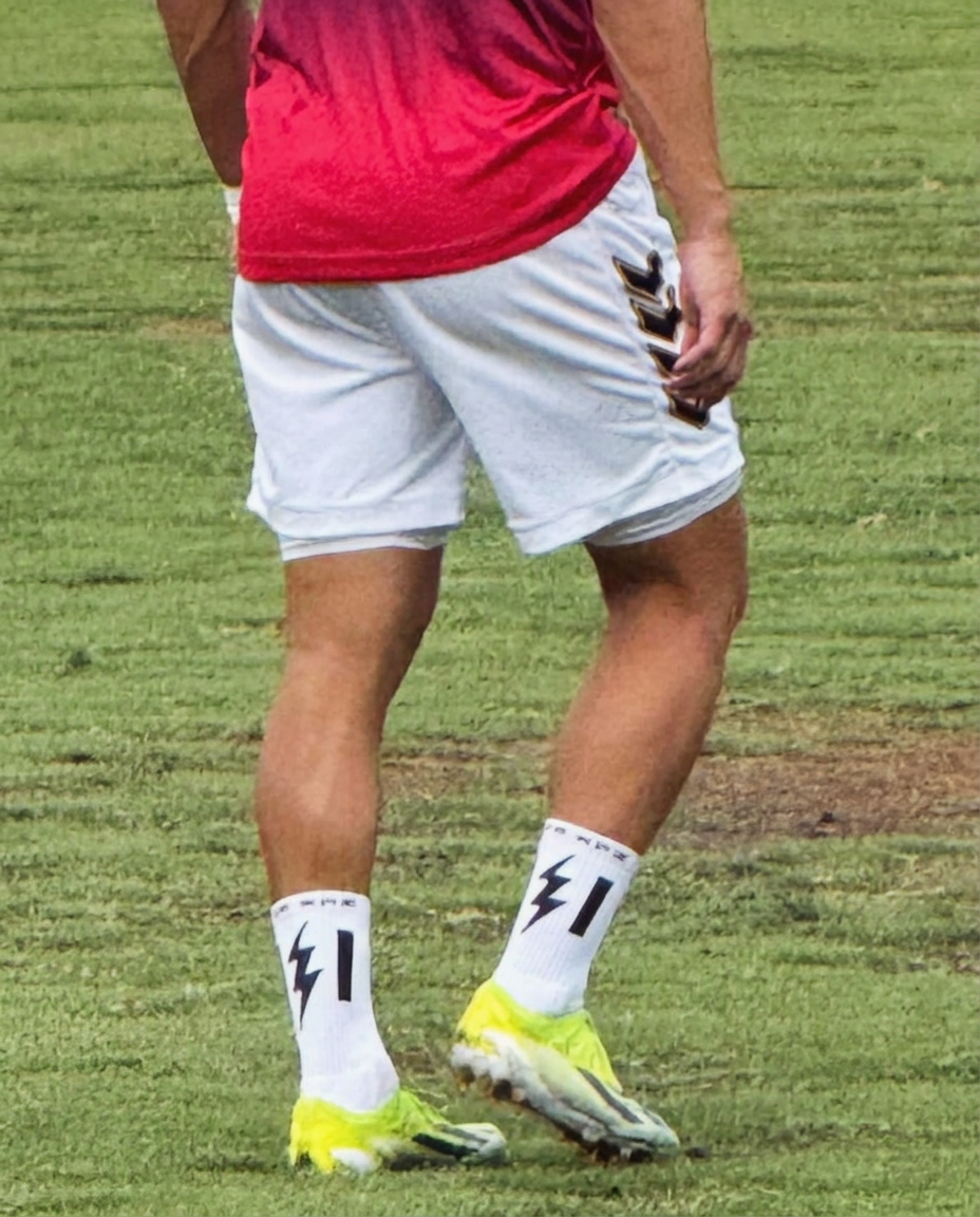 Player on the pitch wearing white STR KRZ grip socks with the bolt logo